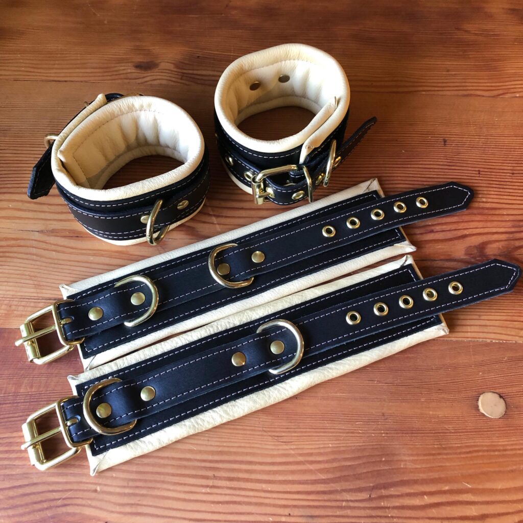 A pair of black and cream custom cuffs and collars