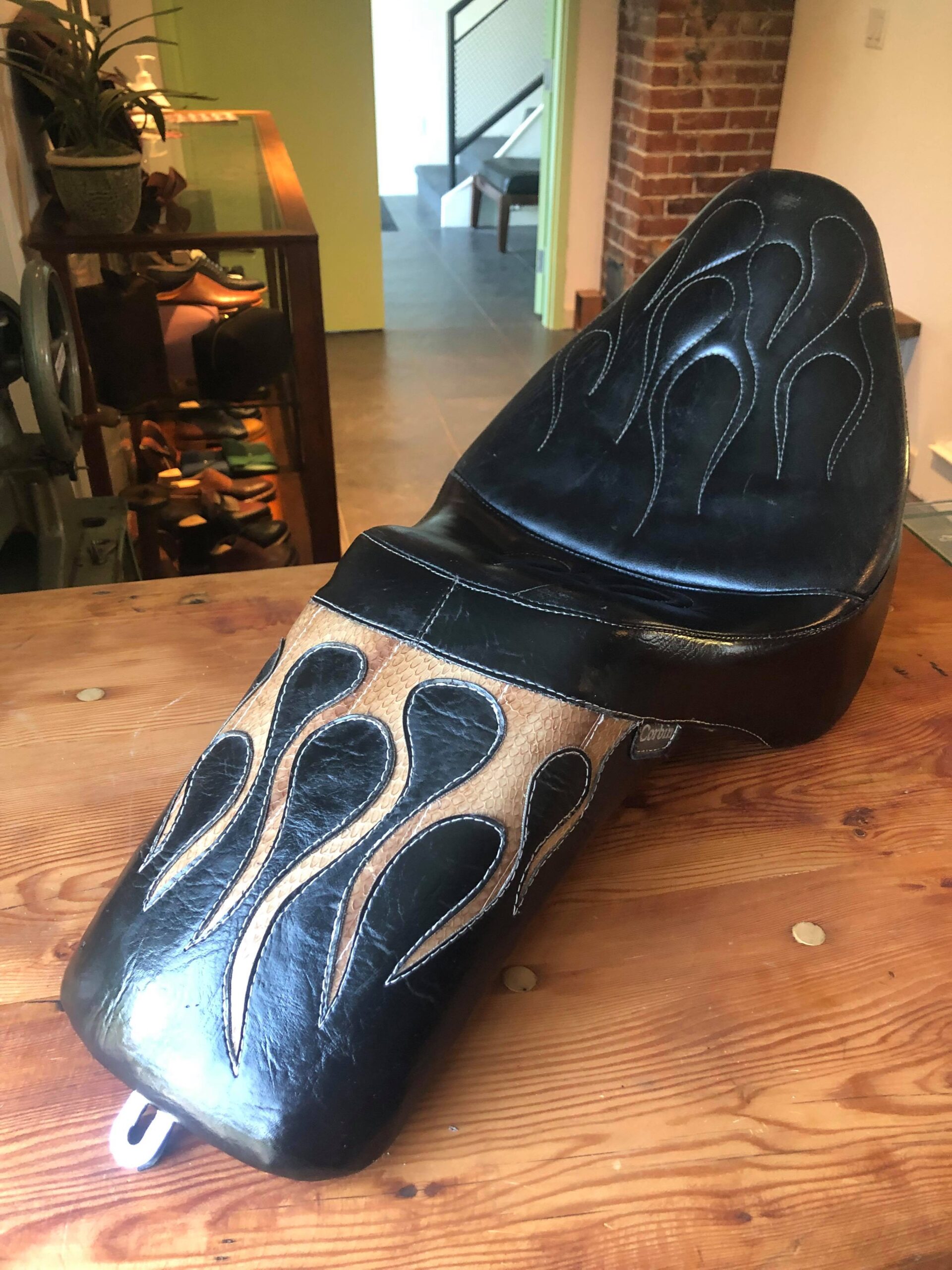 A custom upholstered motorcycle seat featuring snakeskin flame design