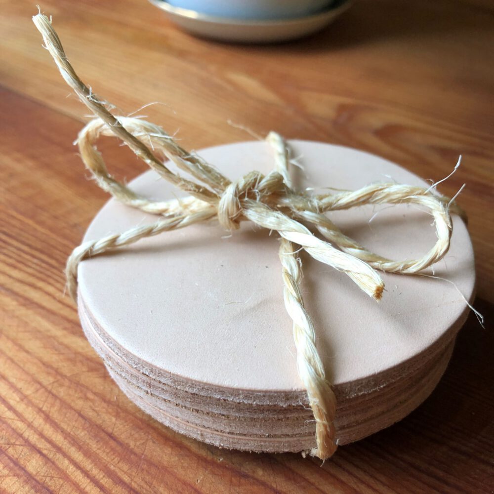 Twine tied around four leather undyed coasters