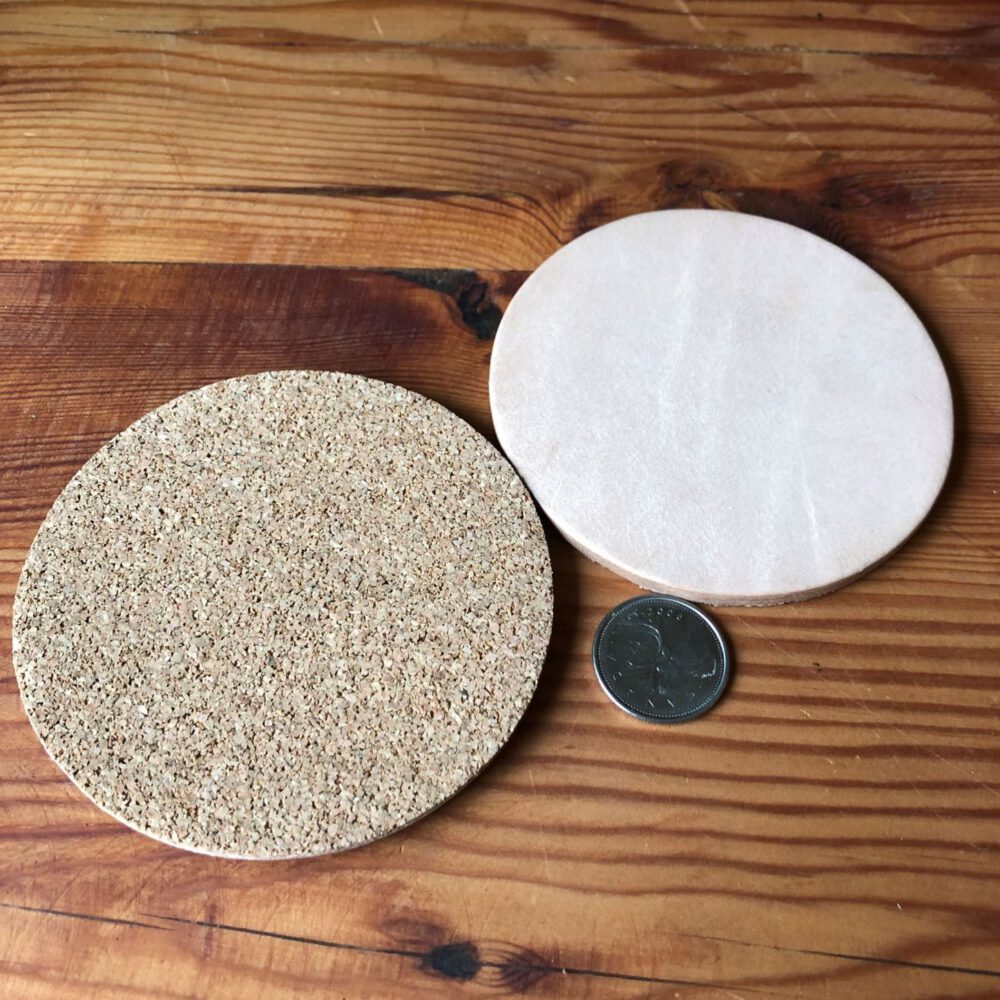 A quarter beside two leather undyed coasters